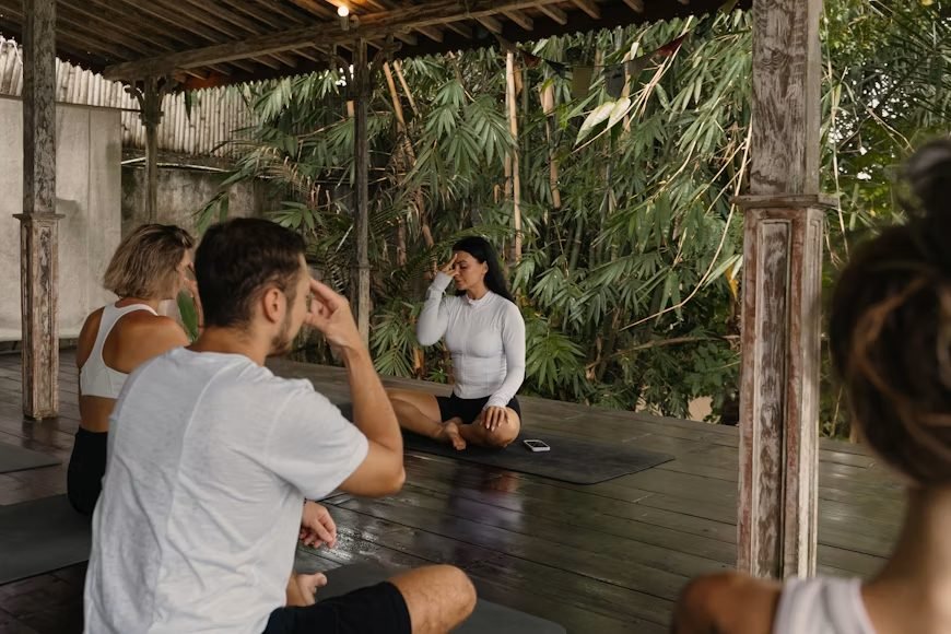 A small group practicing a guided breathing exercise outdoors