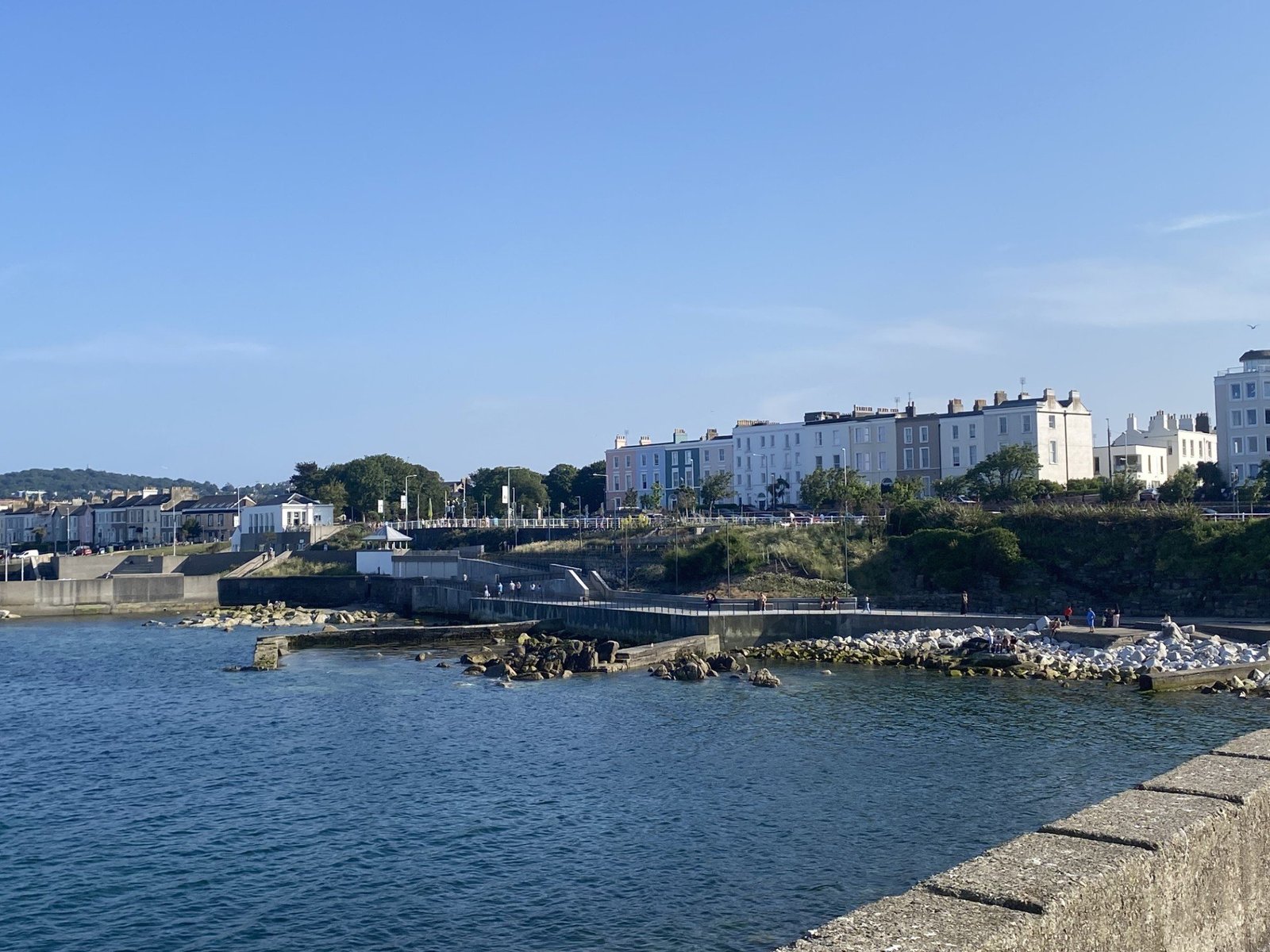 A coastal harbour walkway lined with pastel houses