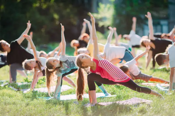 Children practicing yoga outdoors together