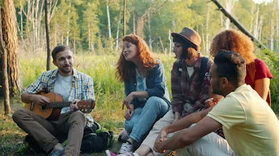 Group gathered with guitar in the forest
